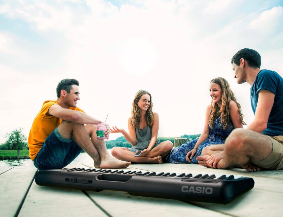 Group Of Young Adults Sitting On Jetty, Relaxing